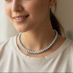 Woman wearing a pearl necklace against a neutral background