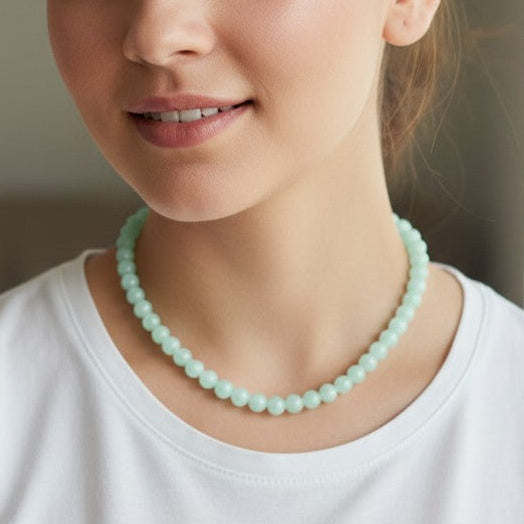 Woman wearing a light blue beaded necklace indoors