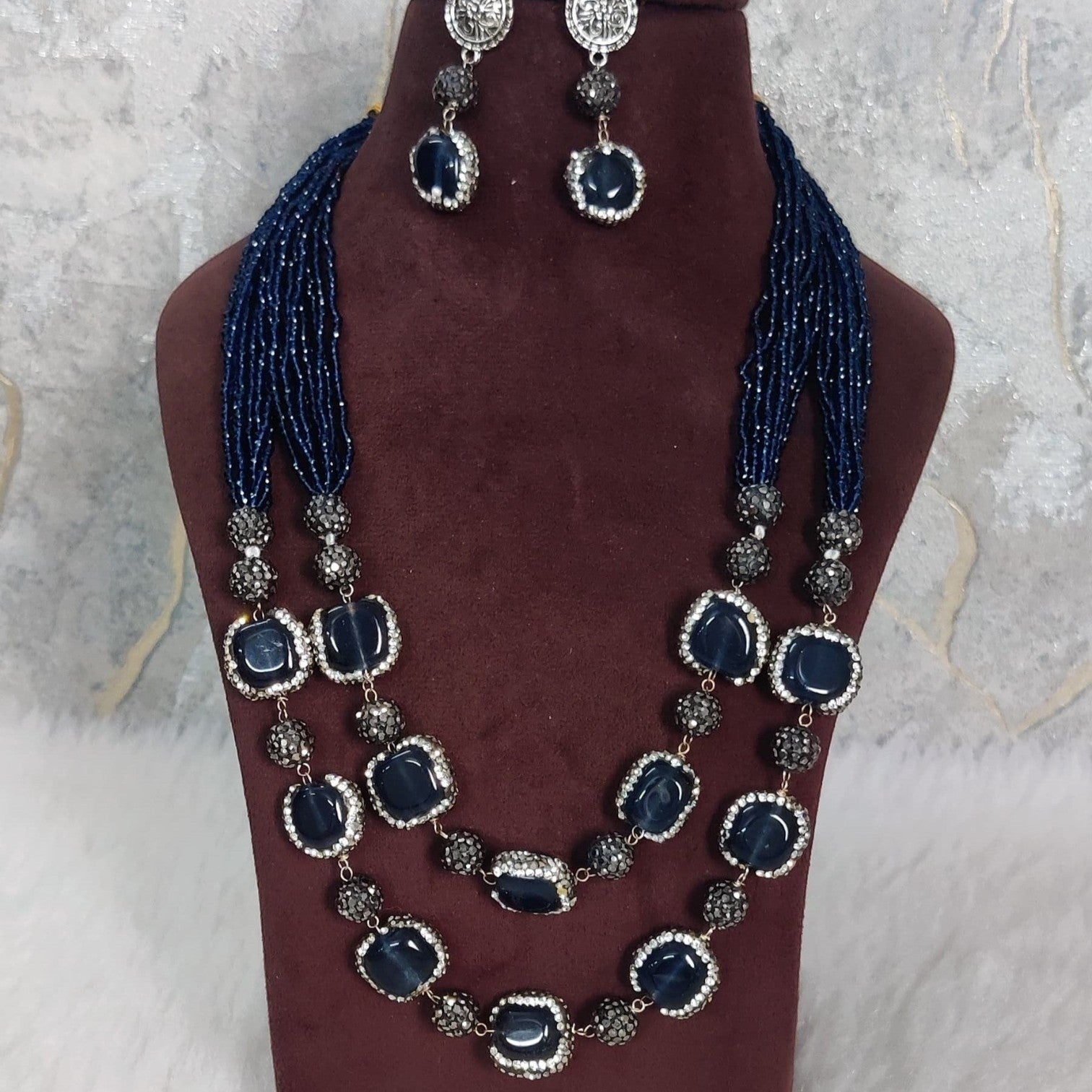 JewelOn Nilambari blue semiprecious stone necklace and earring set with gold-plated metal. Features deep blue stones and intricate detailing.