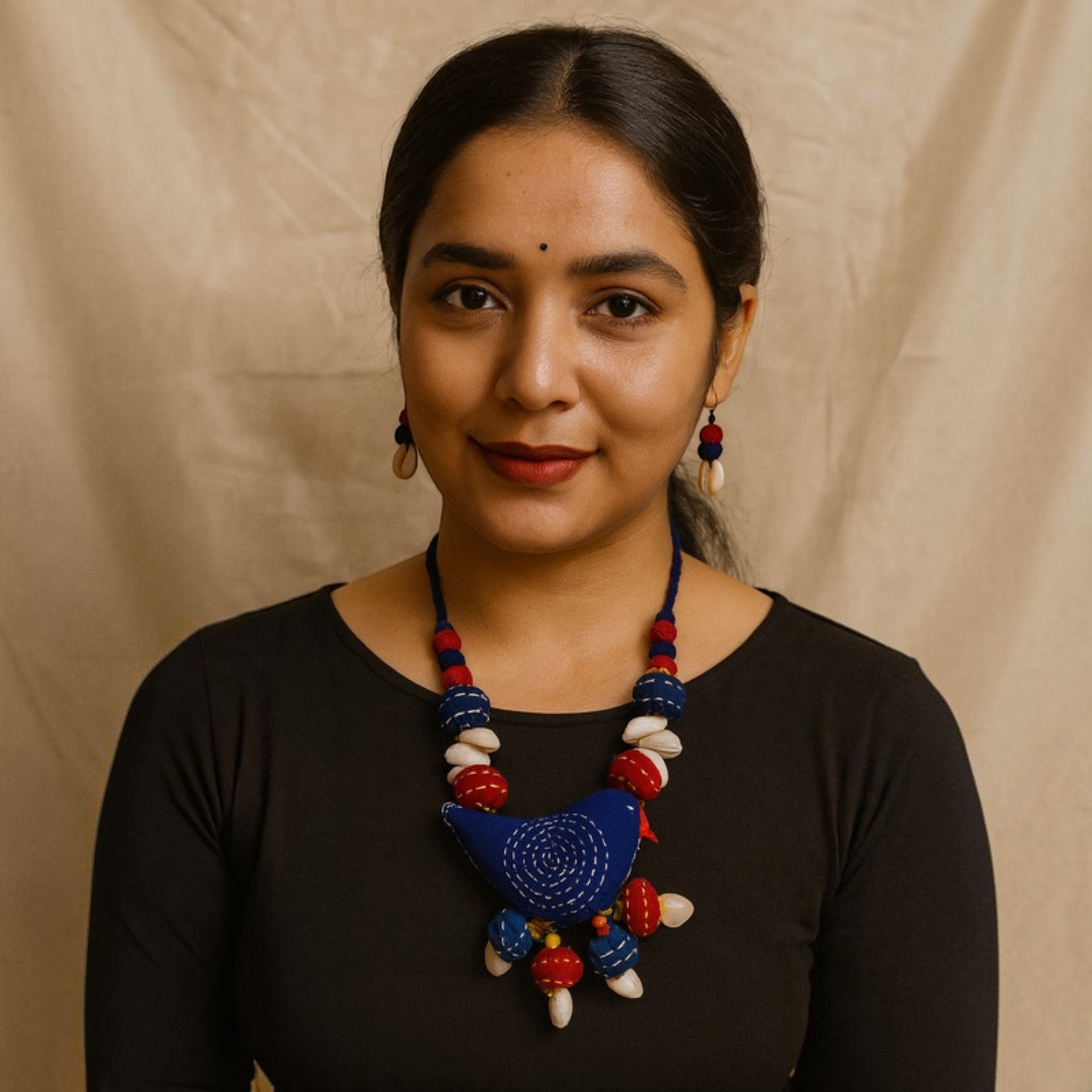 JewelOn blue fabric bird necklace with red and white beads and shell accents, matching earrings