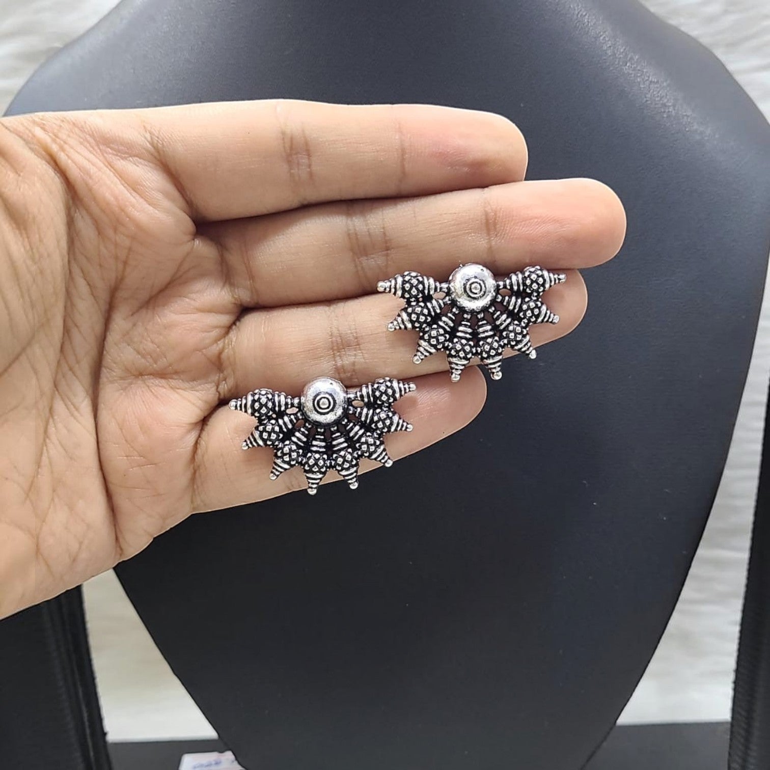 JewelOn Artistic German silver oxidised earrings with intricate detailing and a central circular motif.