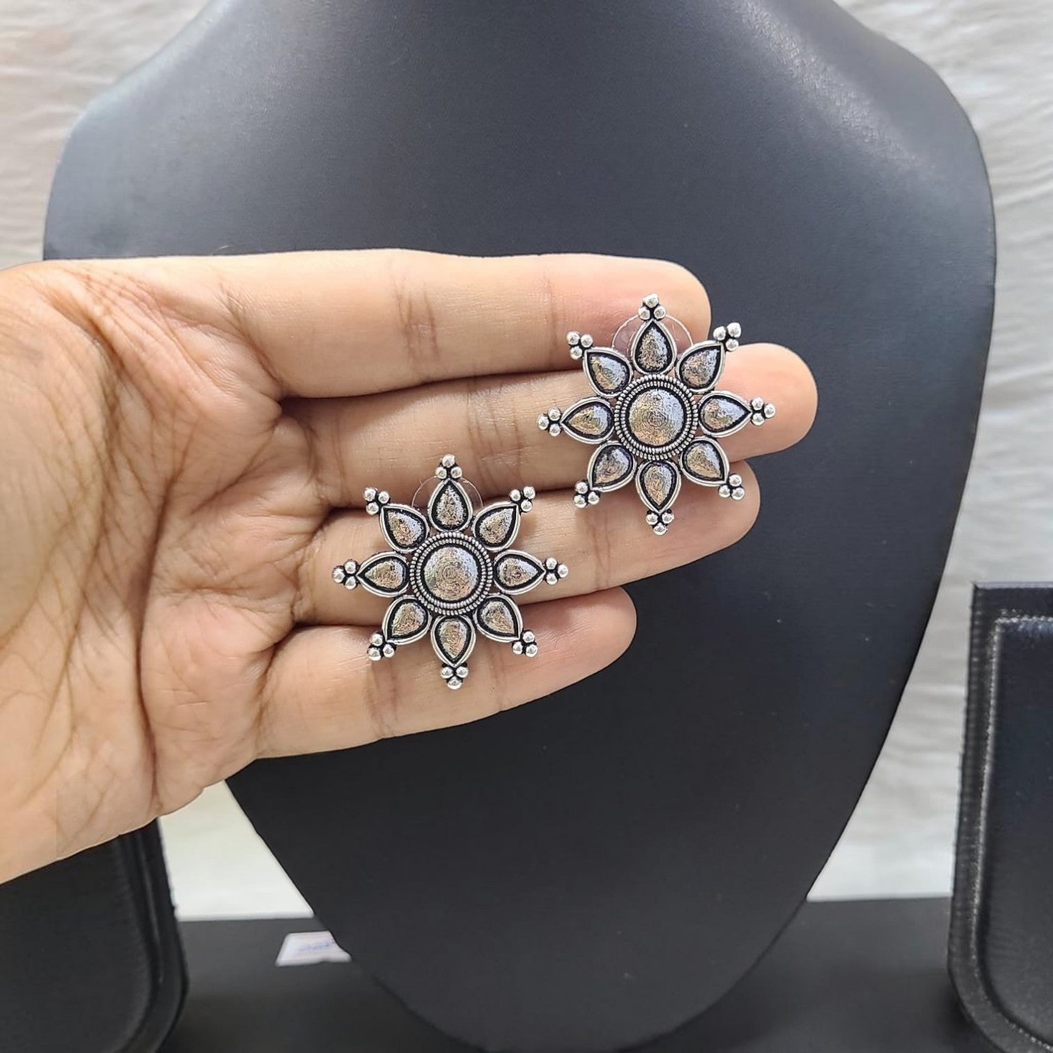 JewelOn German Silver oxidised floral stud earrings with intricate detailing.