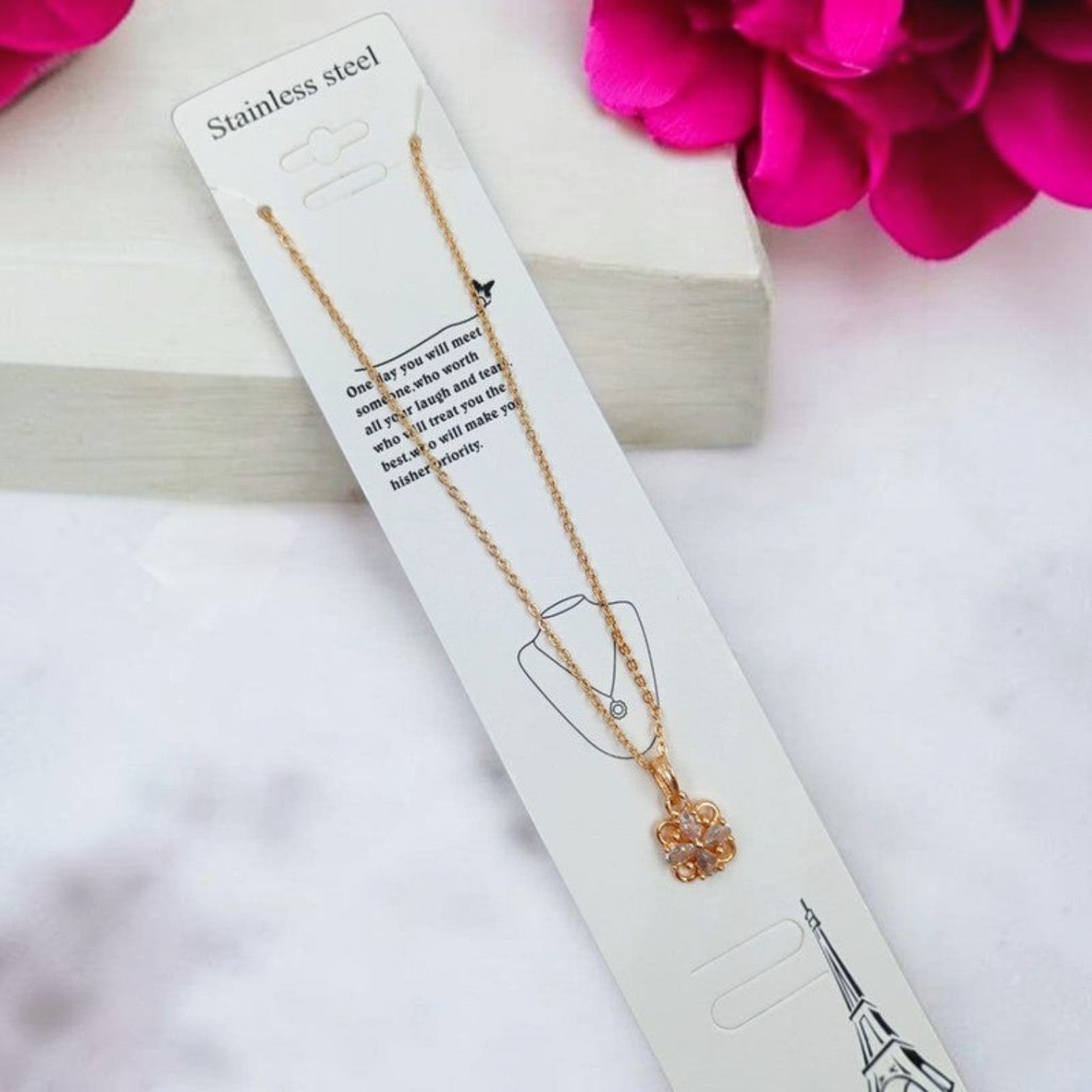 JewelOn gold-tone brass pendant necklace with a floral design and clear stones. Stainless steel chain.