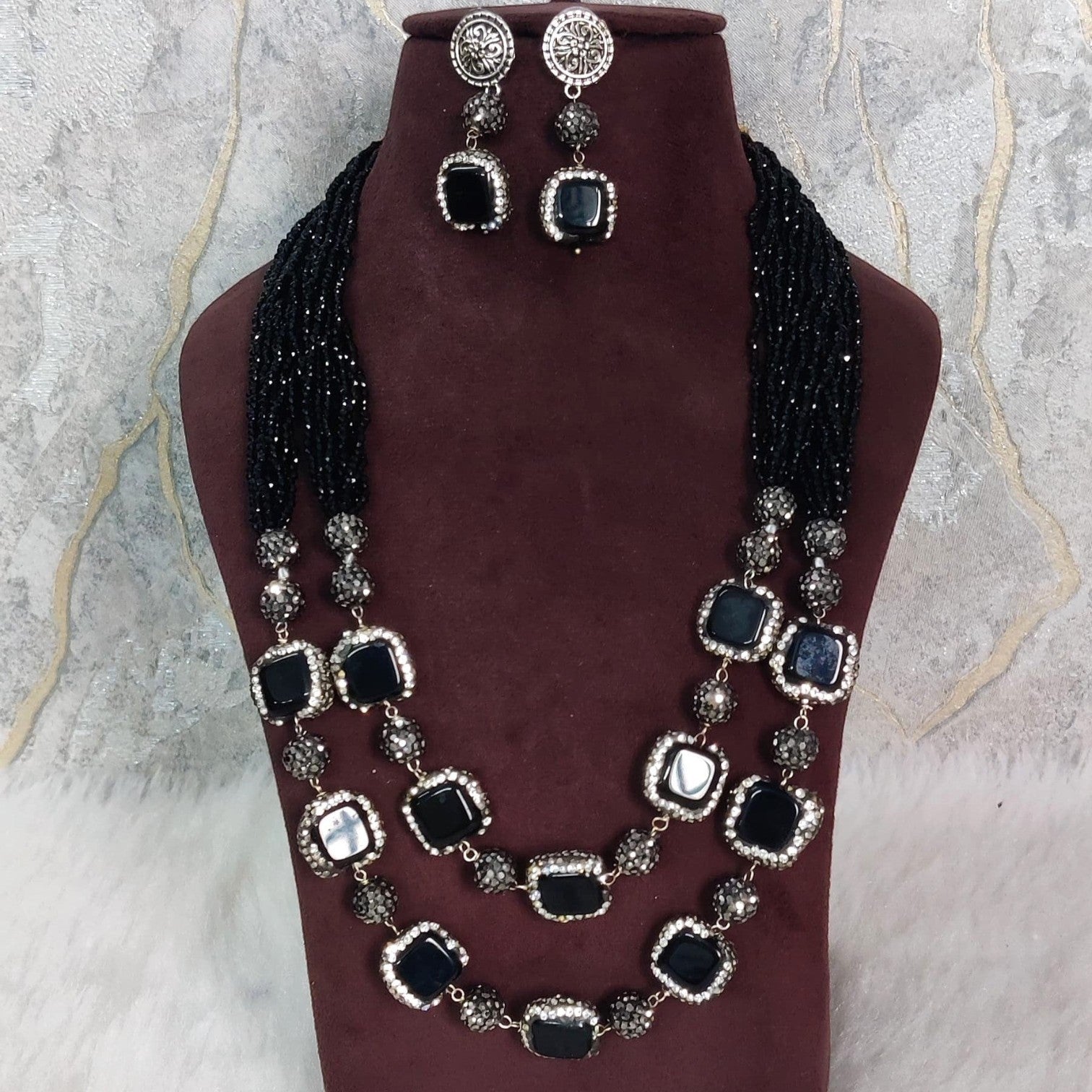 JewelOn Krishnamayi black semiprecious stone necklace and earring set with gold-toned accents.