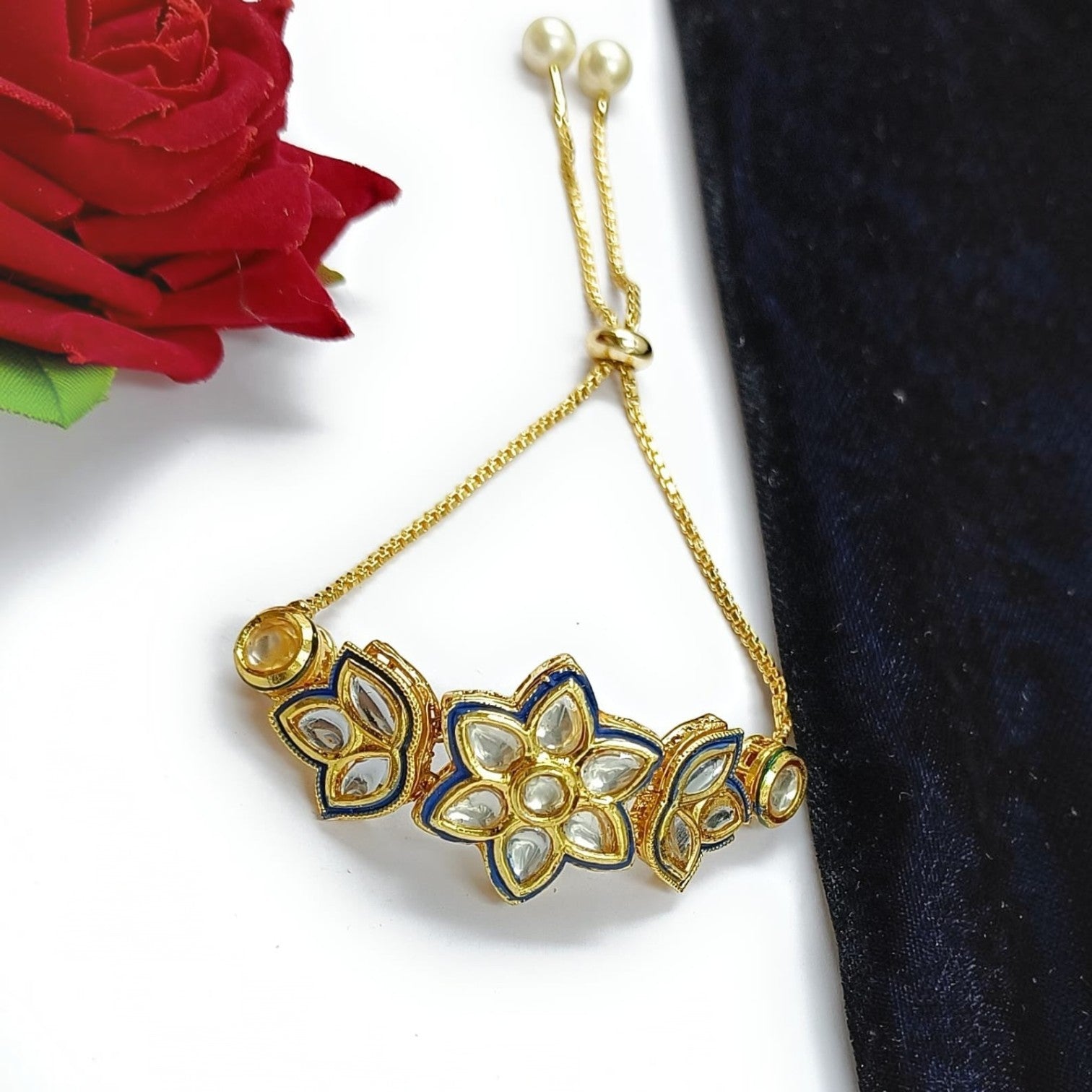 JewelOn gold adjustable bracelet with blue enamel and kundan stones in a floral design. Features pearl accents.