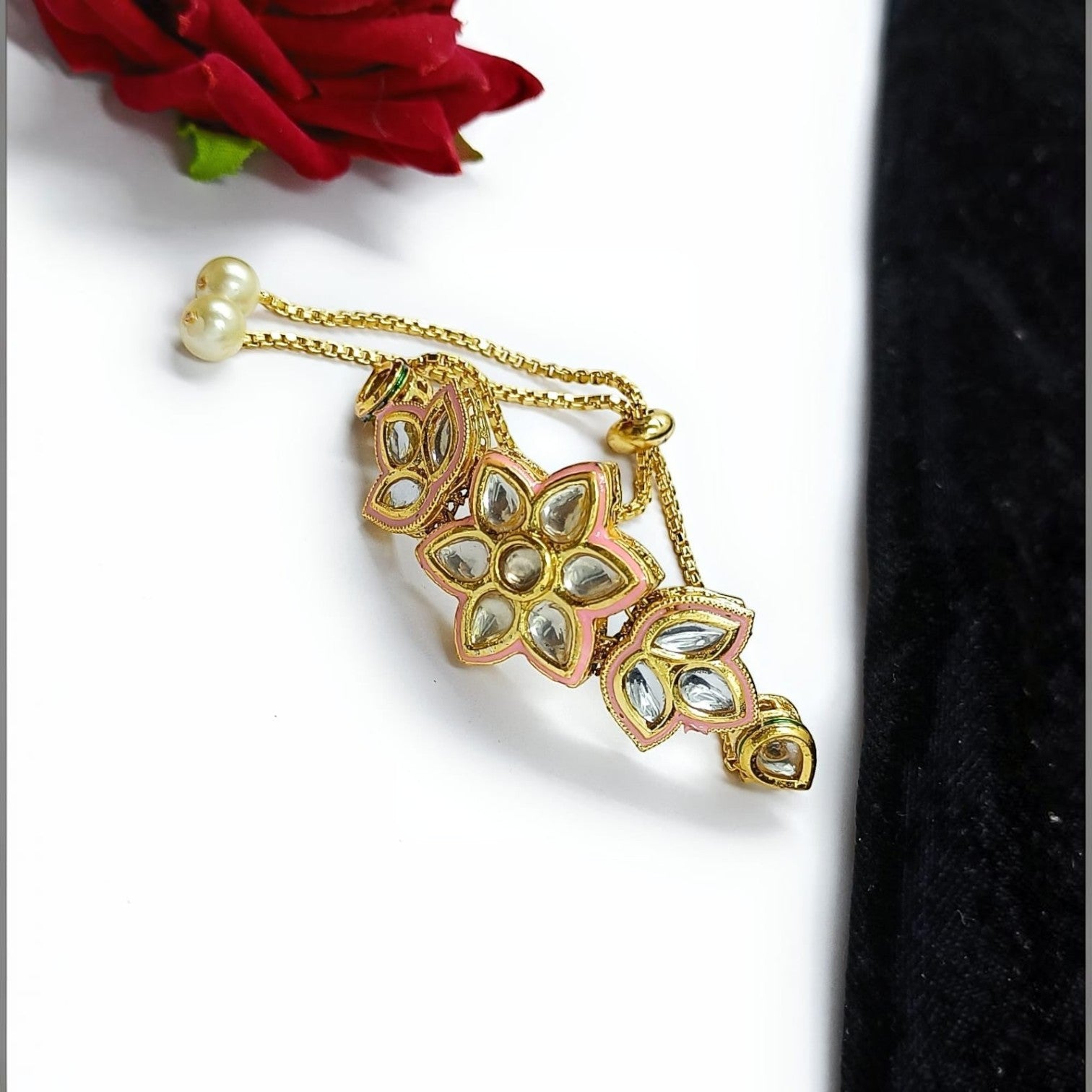 JewelOn gold-tone adjustable bracelet with pink enamel and kundan stones, featuring floral and butterfly motifs and pearl accents.