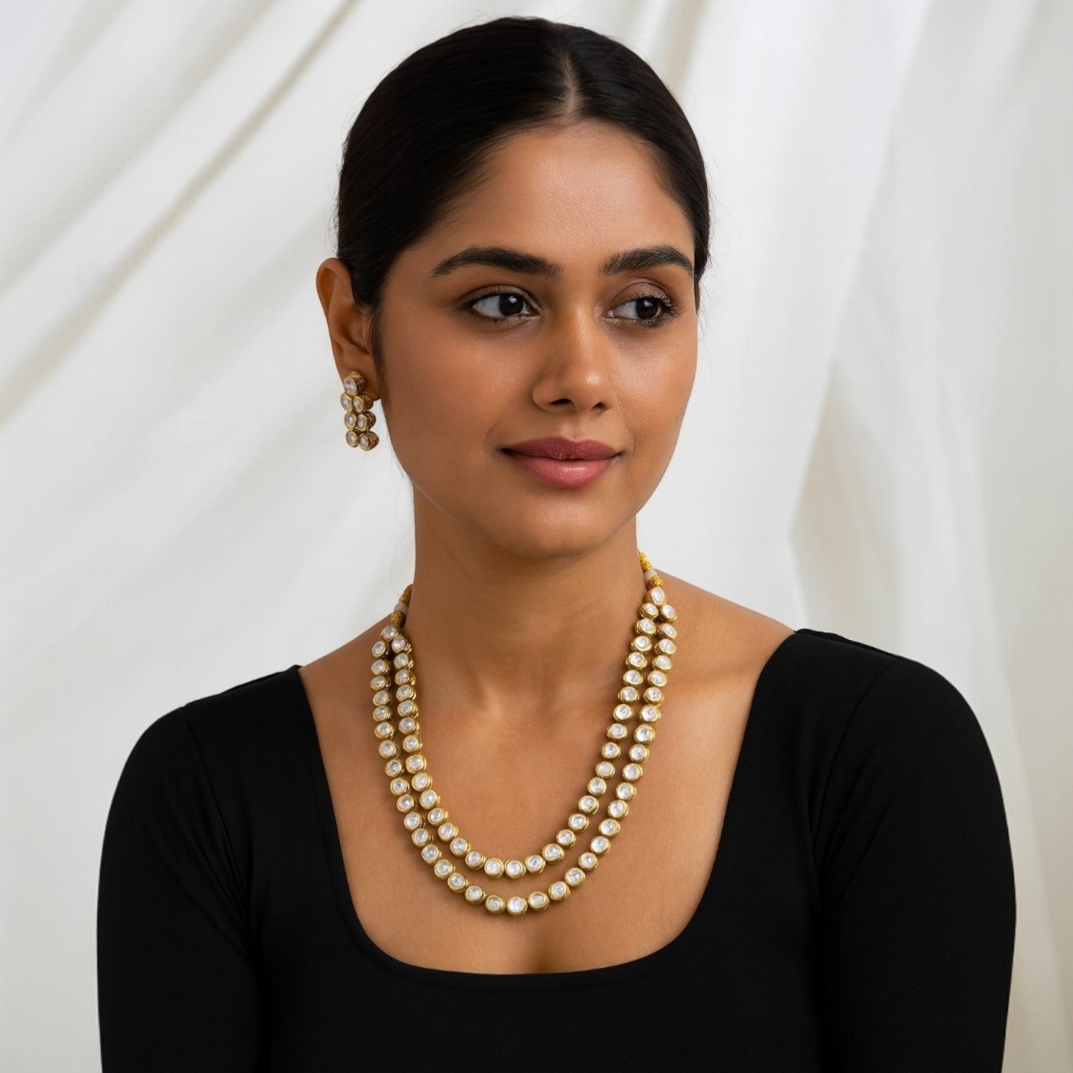 Jewelon gold and white Kundan double line long necklace and earrings set on a woman.