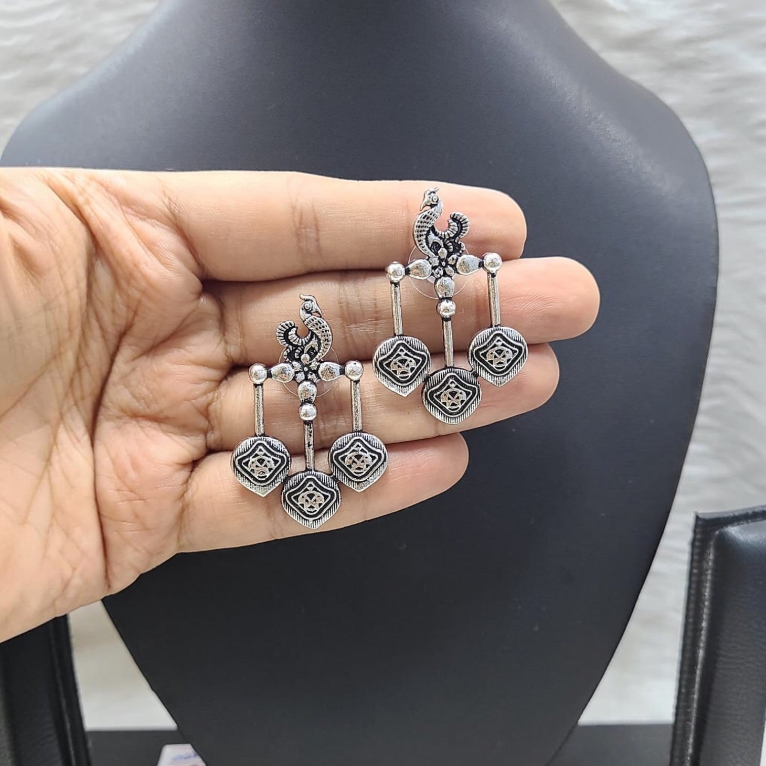 JewelOn handcrafted German silver oxidised earrings with peacock motif and dangling square charms.