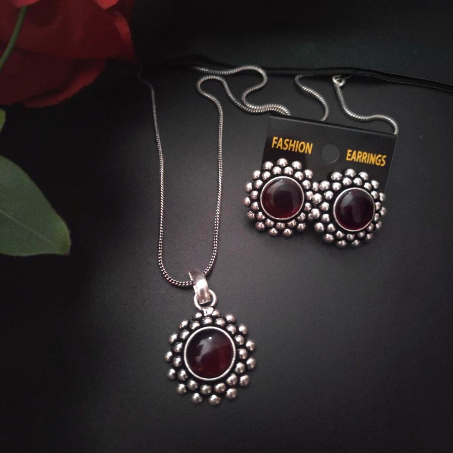 JewelOn oxidised silver pendant necklace and matching stud earrings with deep red stone centres and beaded borders.