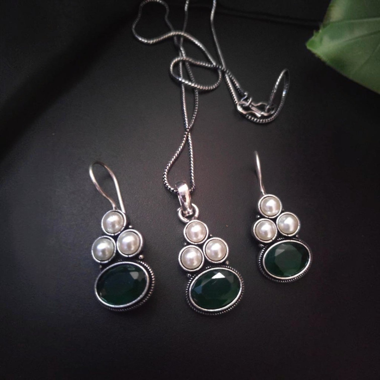 JewelOn oxidised pendant necklace and earrings set with green oval stones and pearls.
