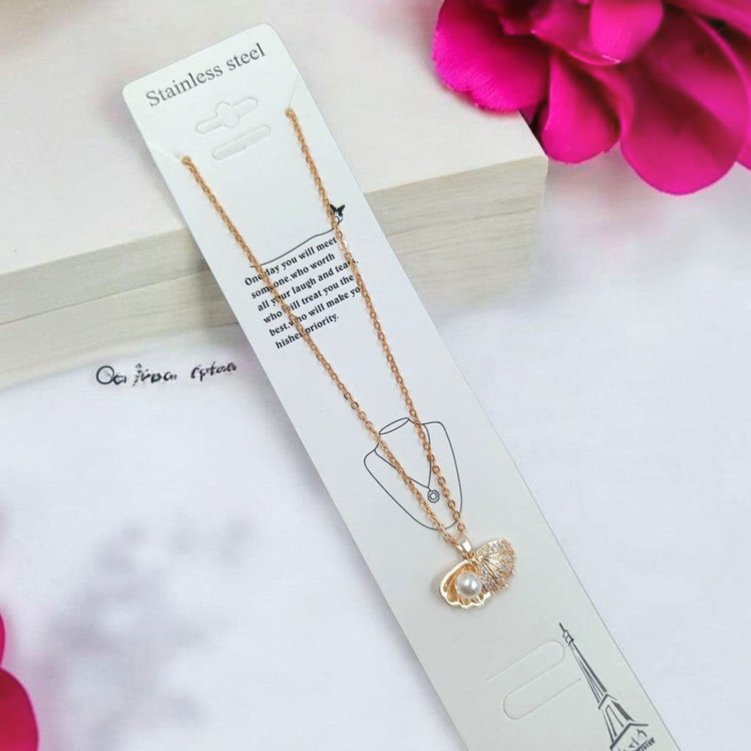 JewelOn rose gold chain necklace with a seashell pendant featuring a pearl accent. Stainless steel.