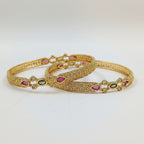 JewelOn Lumière gold plated bangles set for women, featuring intricate filigree design with pink and green teardrop stones and small clear crystals.