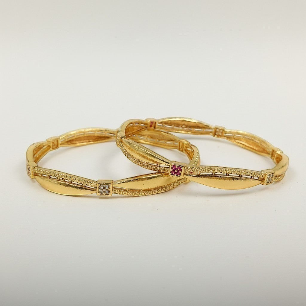 JewelOn gold plated bangles set with intricate detailing and small square cubic zirconia and ruby accents.