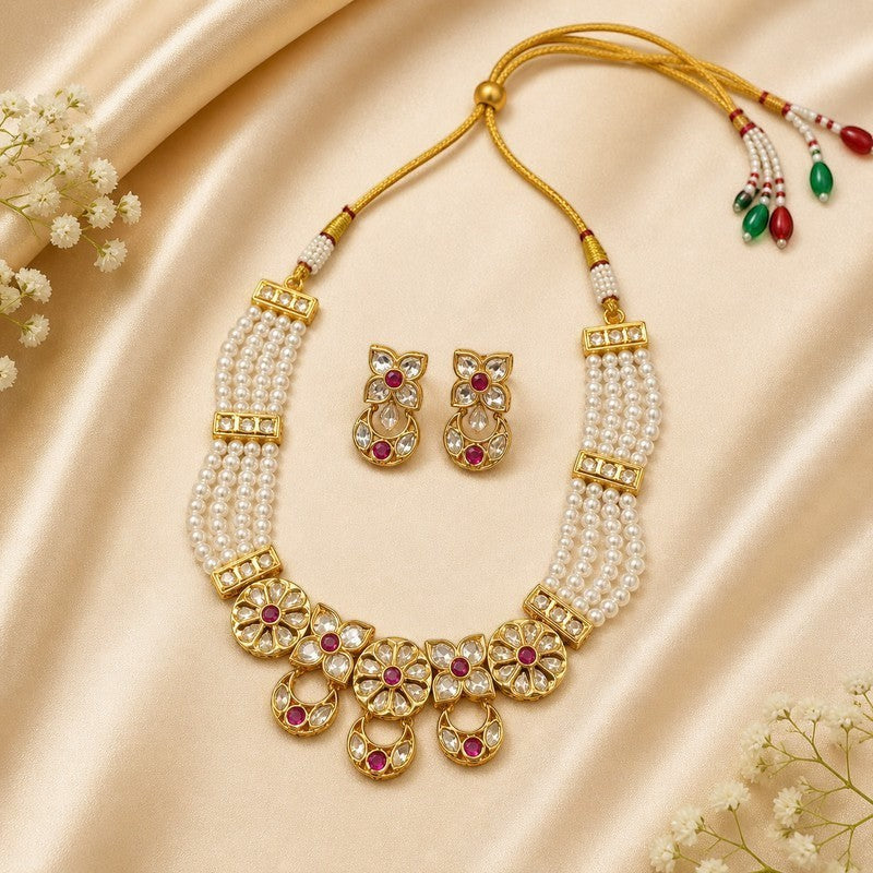 JewelOn gold-toned choker necklace set with multiple strands of pearls, Kundan stones, and ruby-red accents. Includes matching earrings.