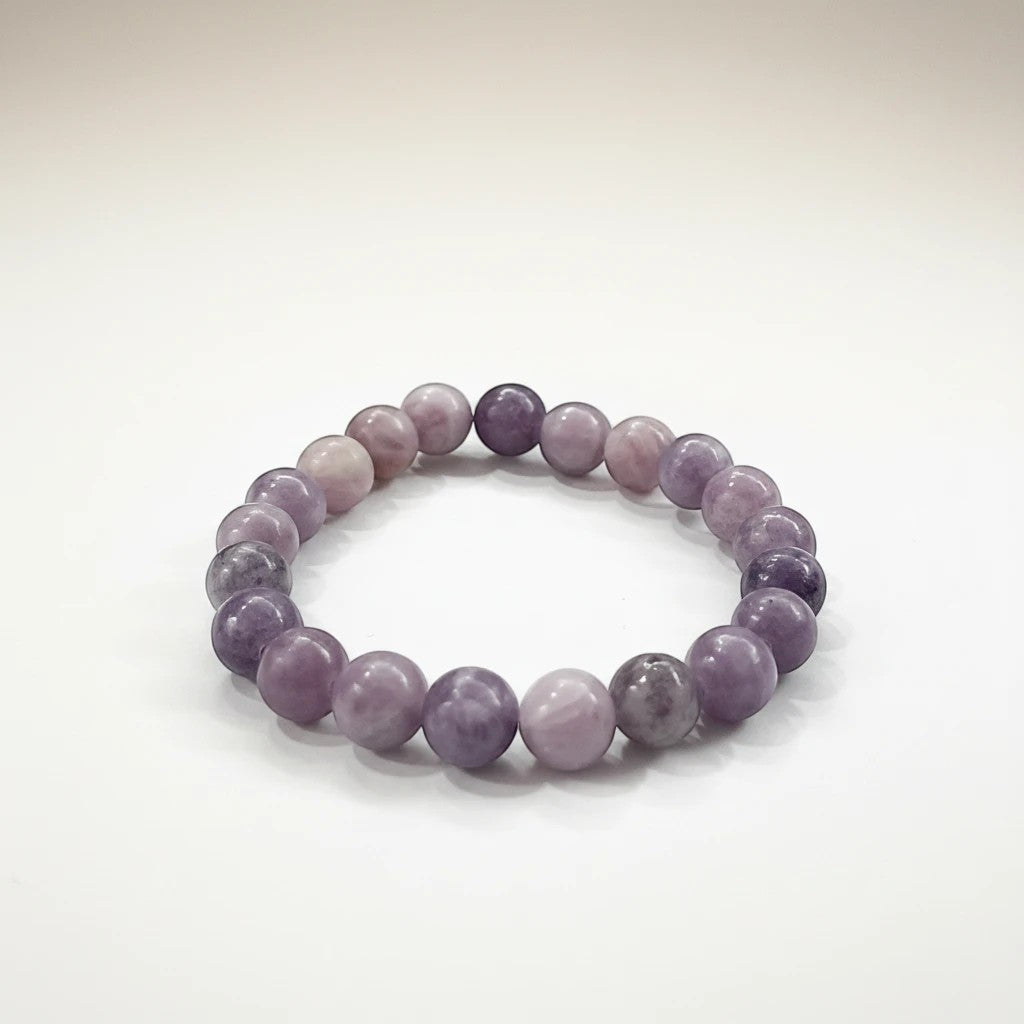 JewelOn Lepidolite 8mm crystal bracelet with smooth, lilac and lavender beads on an elastic band.