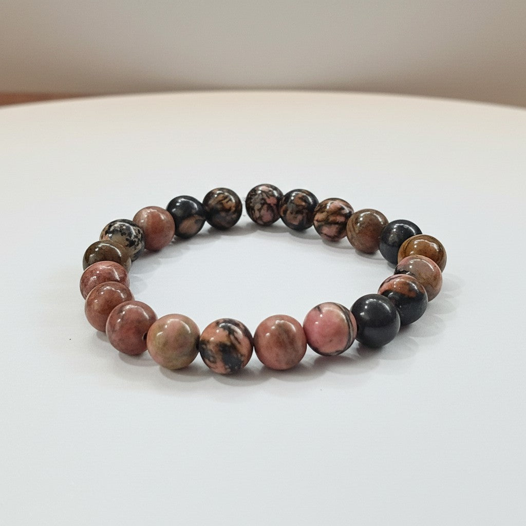 JewelOn 8mm genuine Rhodonite crystal beads bracelet with pink and black inclusions, strung on elastic cord.