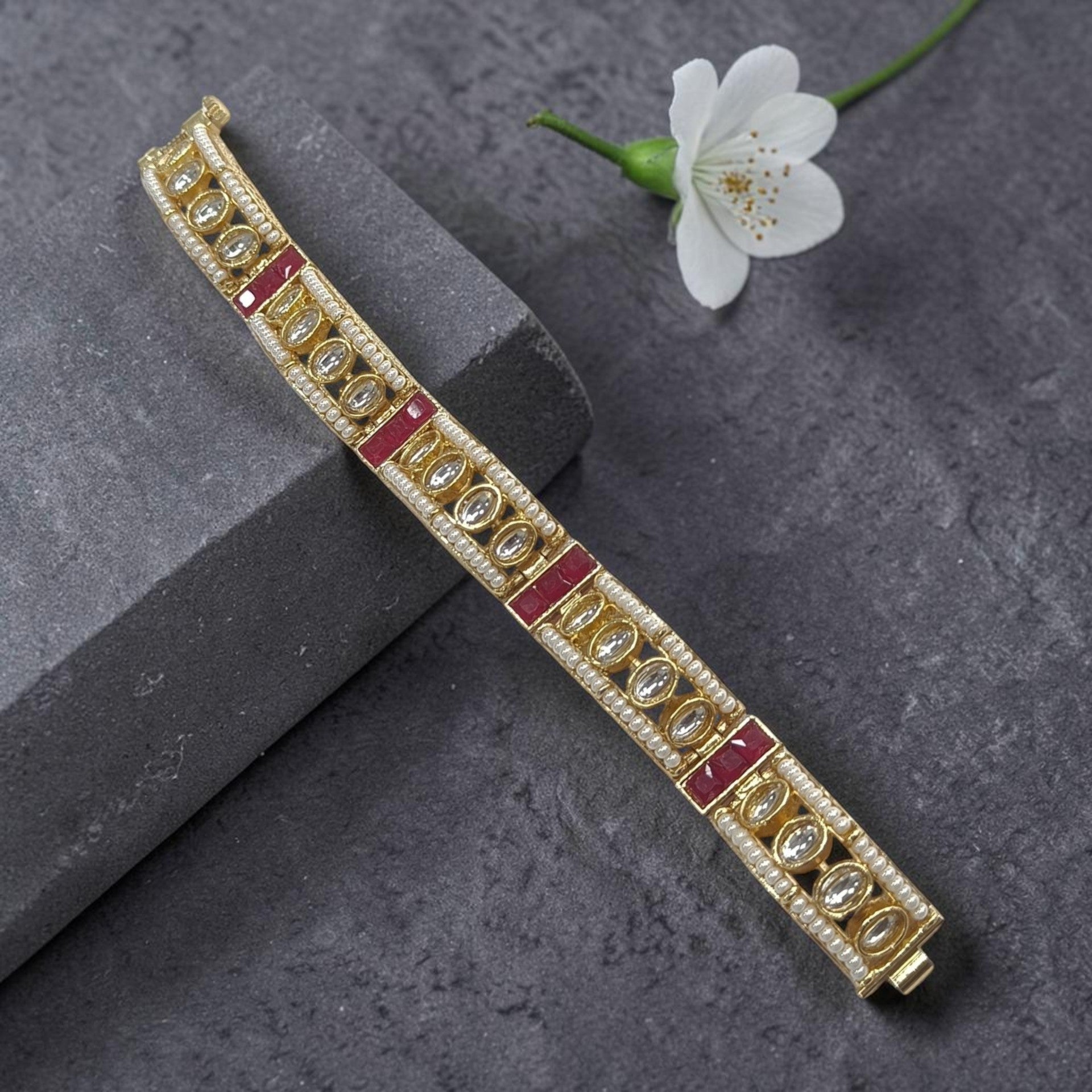JewelOnHere gold gajra bracelet with pearls, clear stones, and red accents.