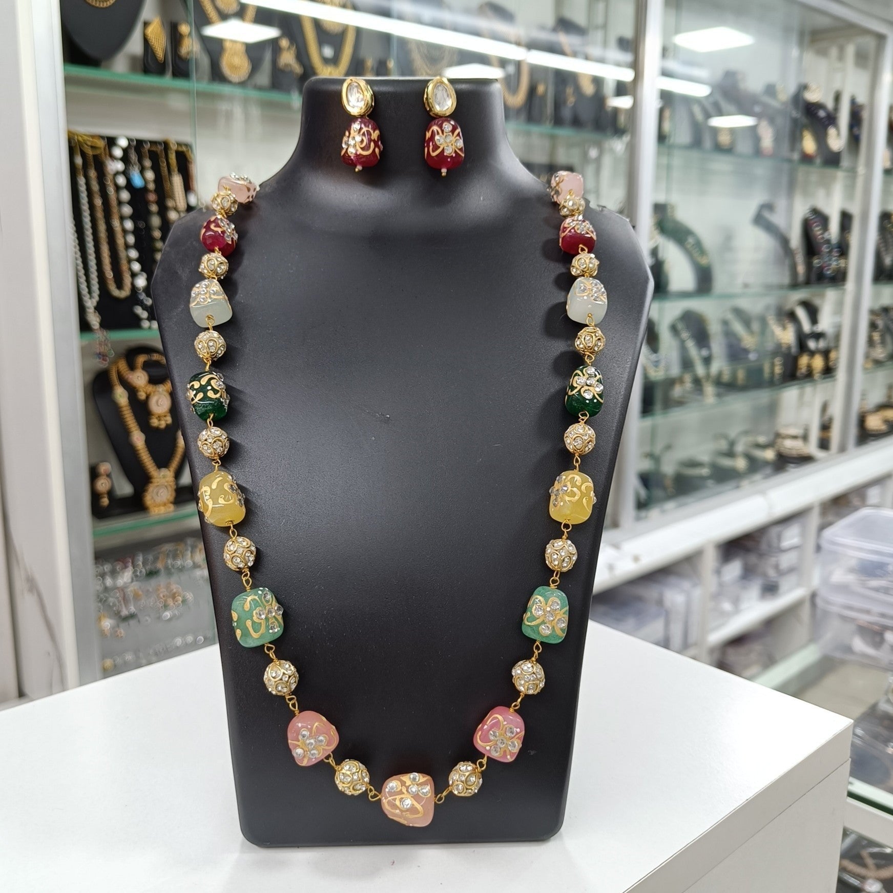 JewelOnHere multi-color semiprecious stone mala necklace and matching earrings with gold accents and intricate carvings.
